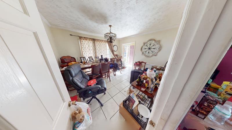 Dining room before fire damage restoration in Jonesboro GA showing smoke staining and clutter