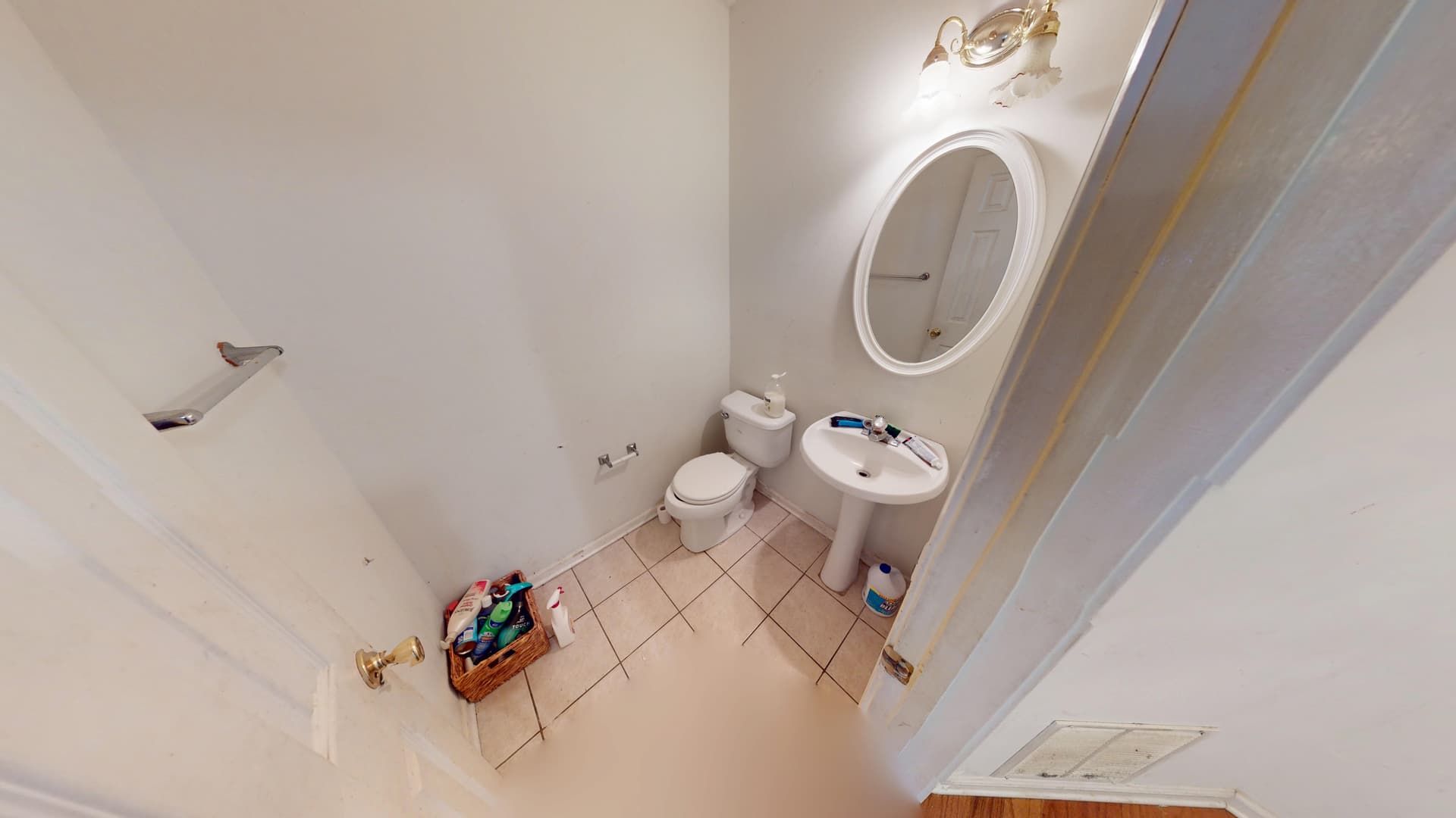 Guest bathroom with water damage to flooring and baseboards before restoration