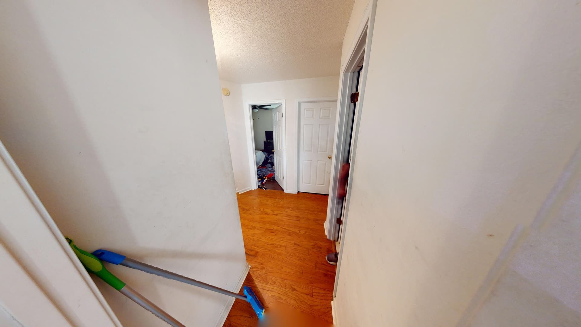 Water-damaged hallway with buckled flooring in Lithonia home before restoration