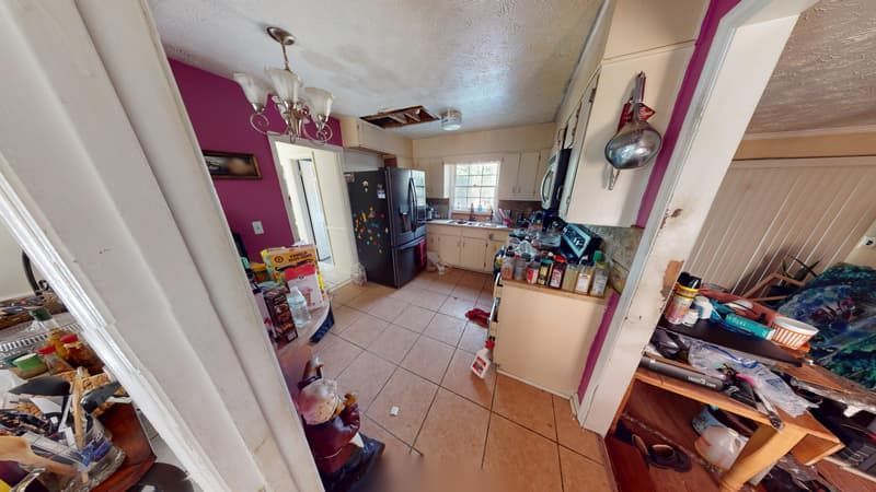 Kitchen before restoration showing collapsed ceiling and heavy soot damage throughout