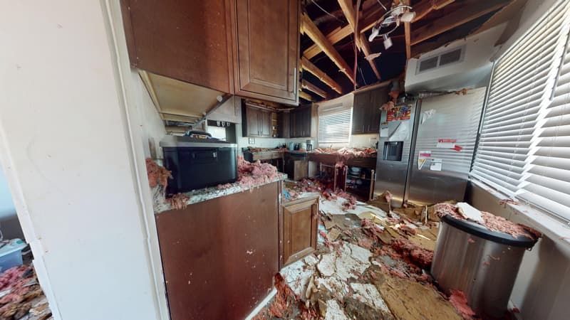 Kitchen before fire damage restoration showing burned surfaces and smoke-stained walls