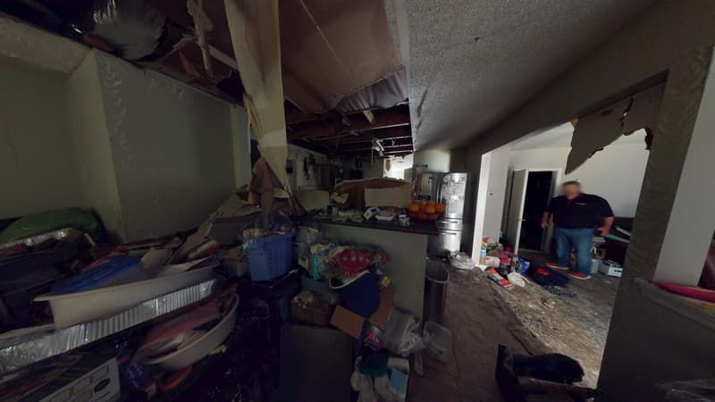 Kitchen fire damage view showing structural cleanup needed before rebuild