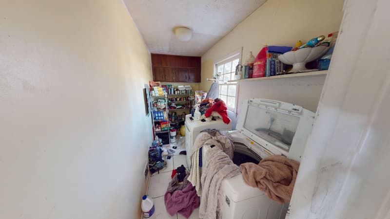 Laundry room before restoration showing cluttered and damaged space after house fire