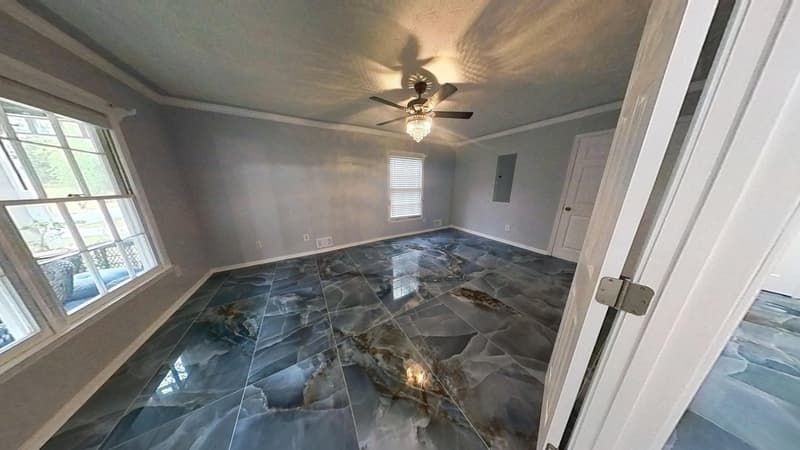 Living room after fire restoration with polished dark tile flooring and clean gray walls