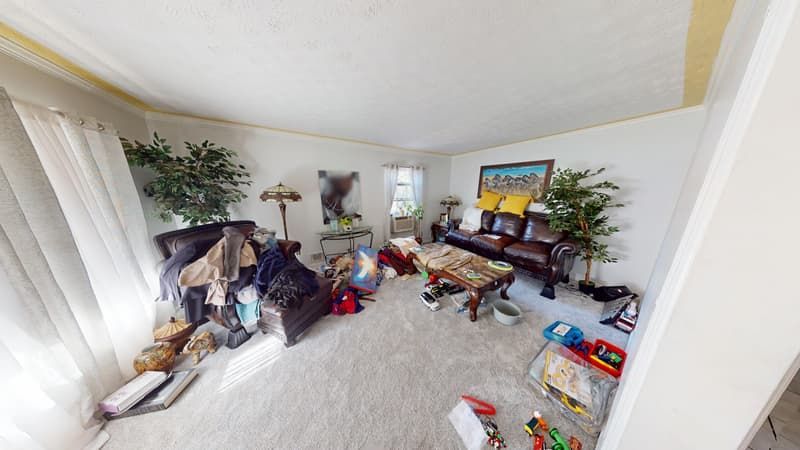 Living room before fire restoration showing smoke staining along ceiling and damaged crown molding