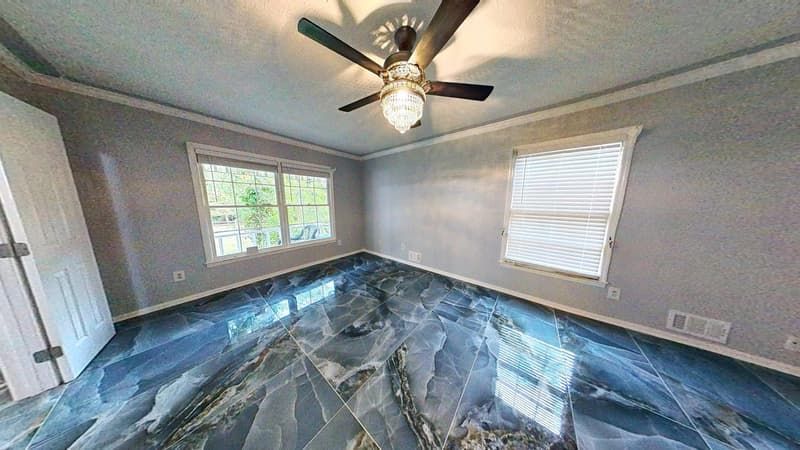 Second living room angle after restoration with new dark tile flooring and updated ceiling fan