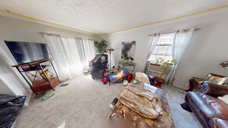 Second living room angle before restoration showing heavy smoke damage along ceiling and walls