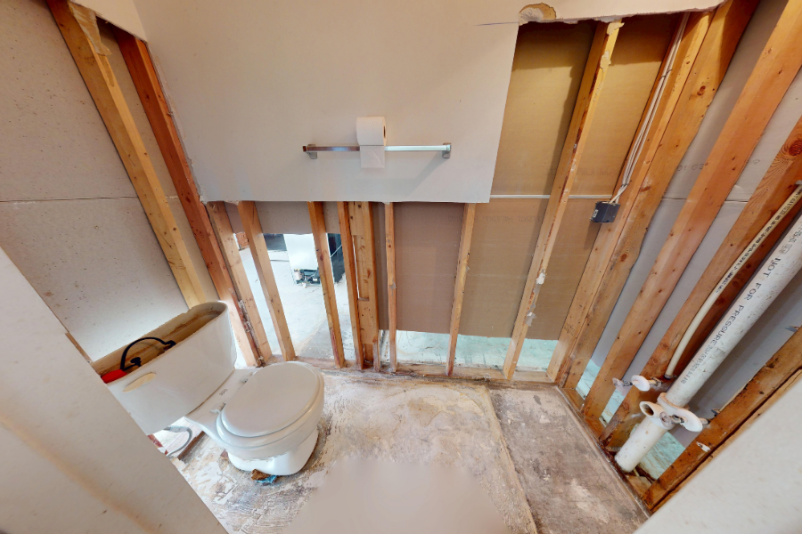 IICRC-certified technician inspecting and repairing structural water damage to walls and framing during professional restoration