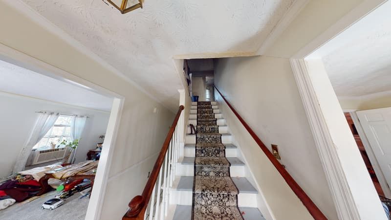 Staircase before fire restoration showing soot on walls and damaged runner carpet