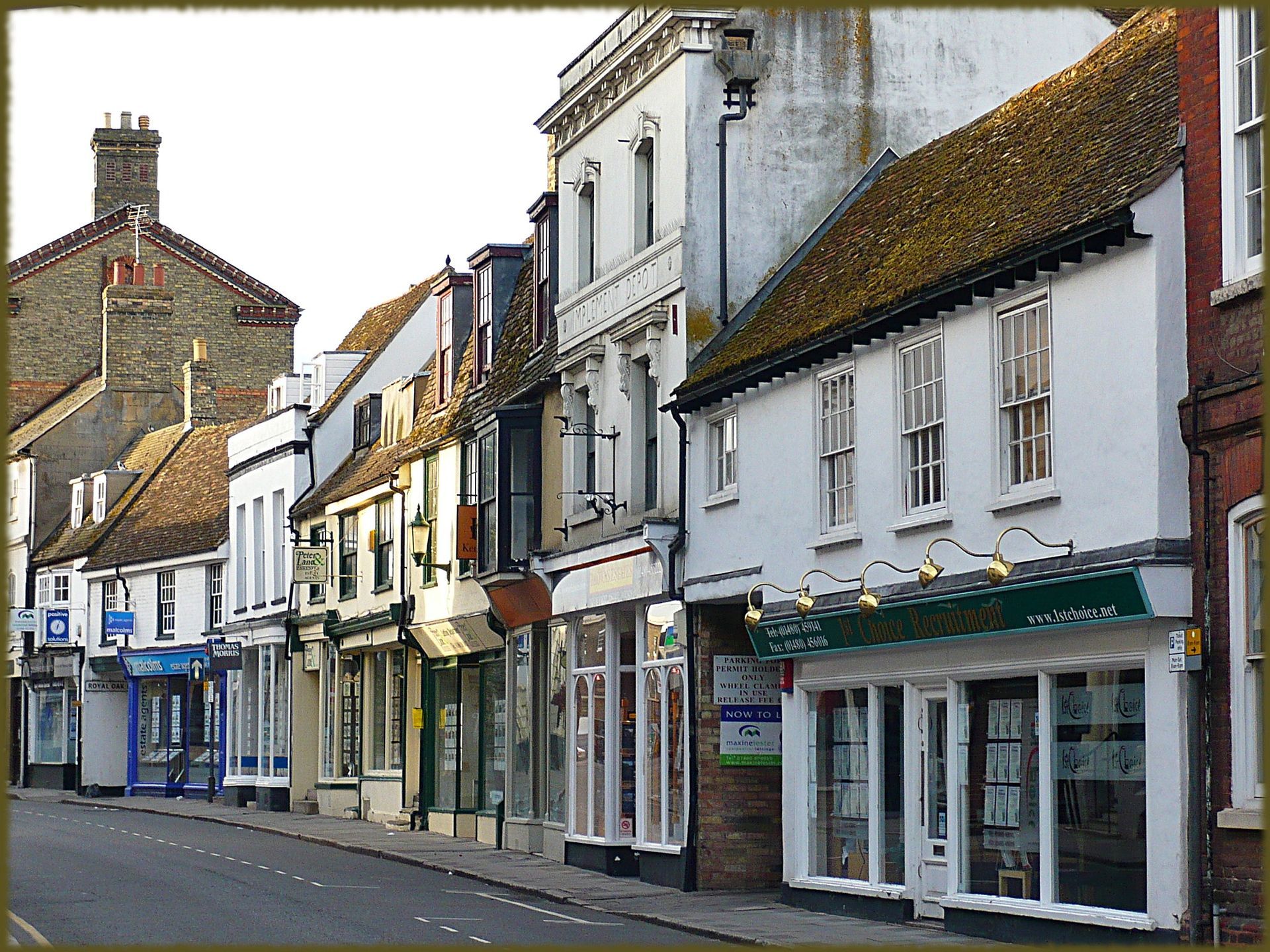 Black flat roof over white framed windows, under a brown tiled roof, with white gutter.