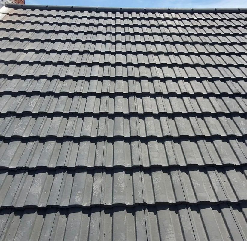 Gray tiled roof with a tool resting on it.