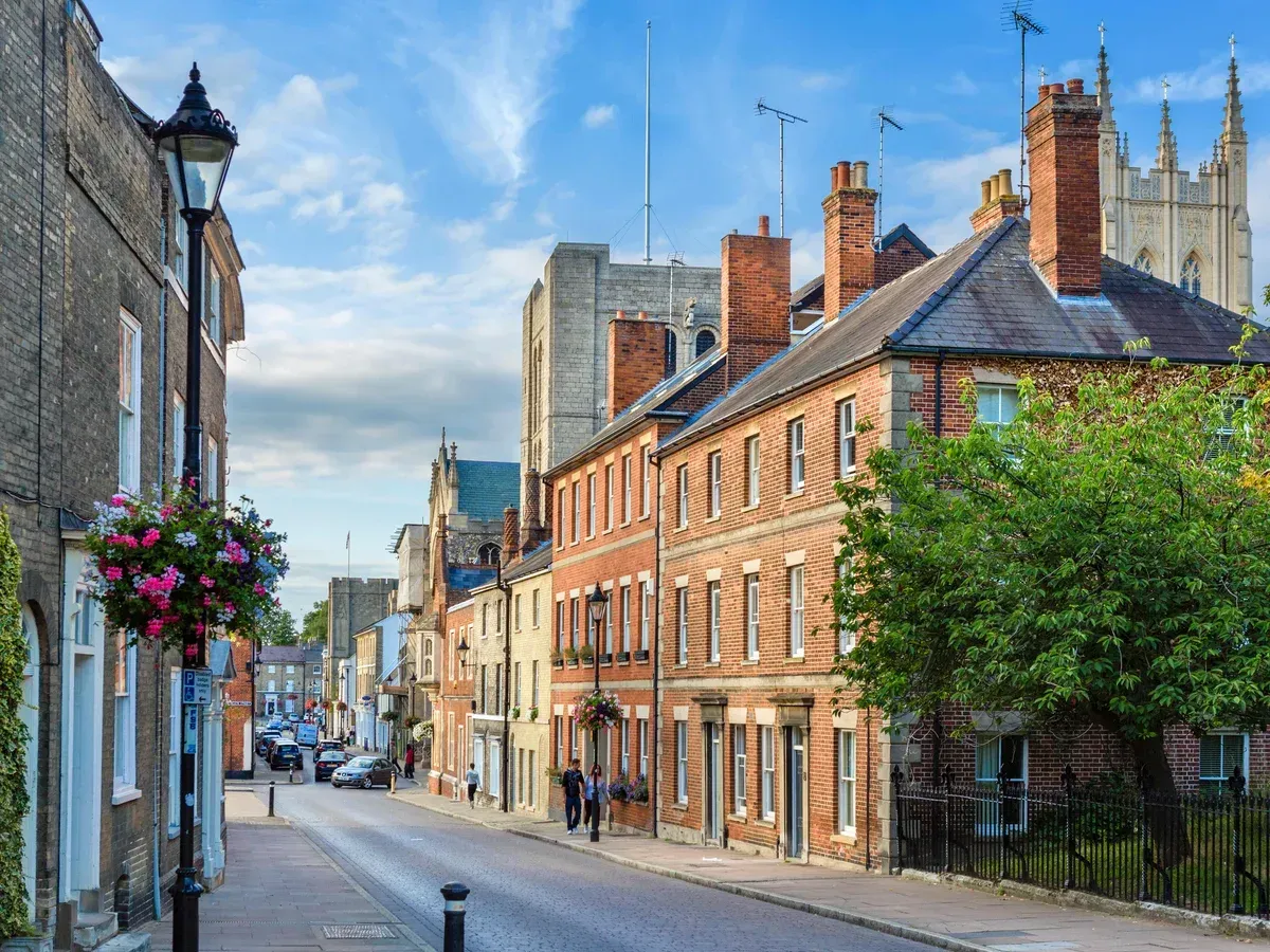 Black flat roof over white framed windows, under a brown tiled roof, with white gutter.