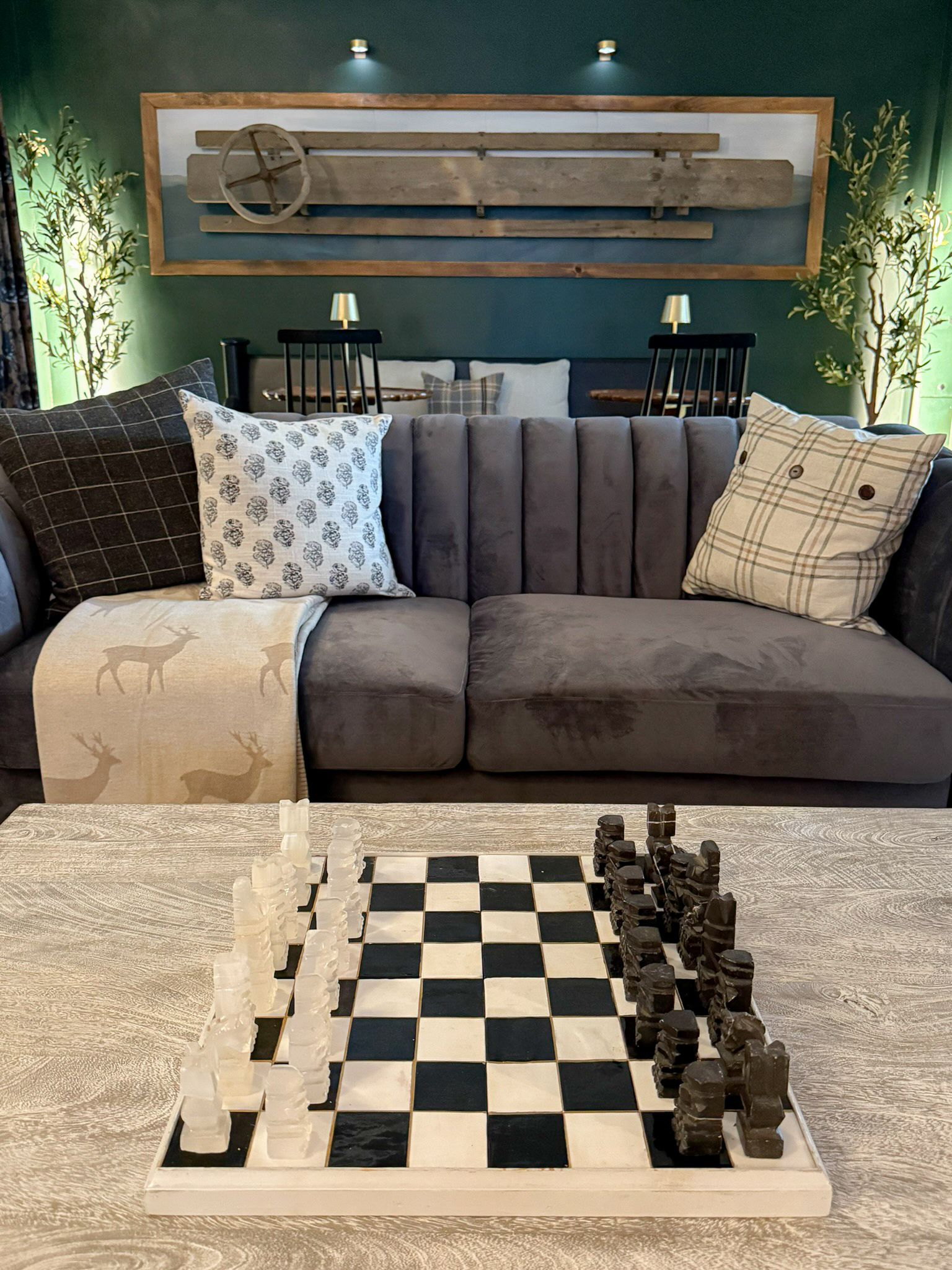 A living room with a couch and a chess board on the table.