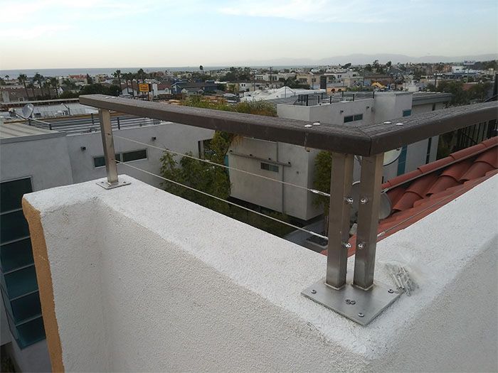 A view of a city from a balcony with a stainless steel railing