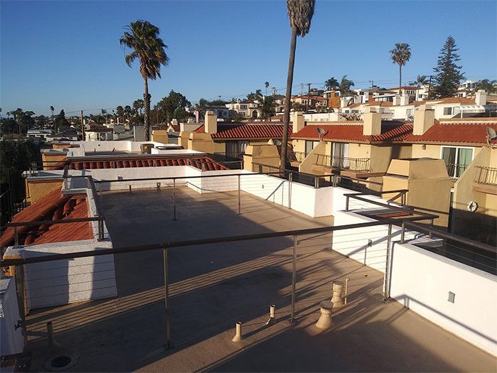 A view of a city from a balcony with palm trees in the background