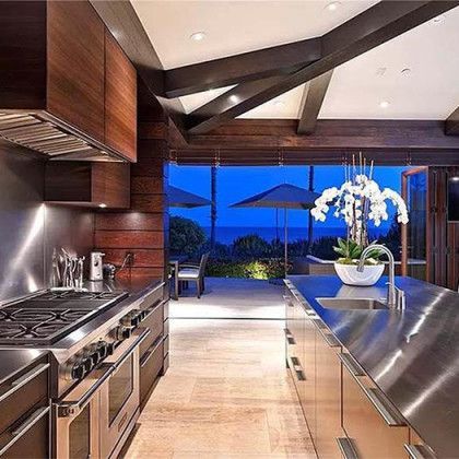 A kitchen with stainless steel appliances and a view of the ocean