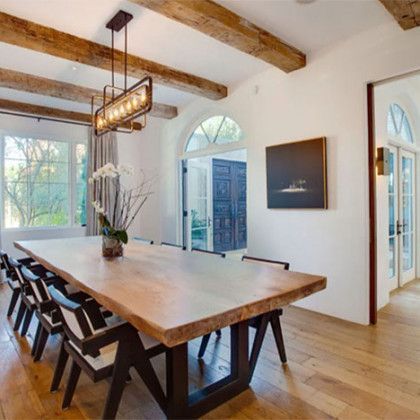 A dining room with a long wooden table and chairs