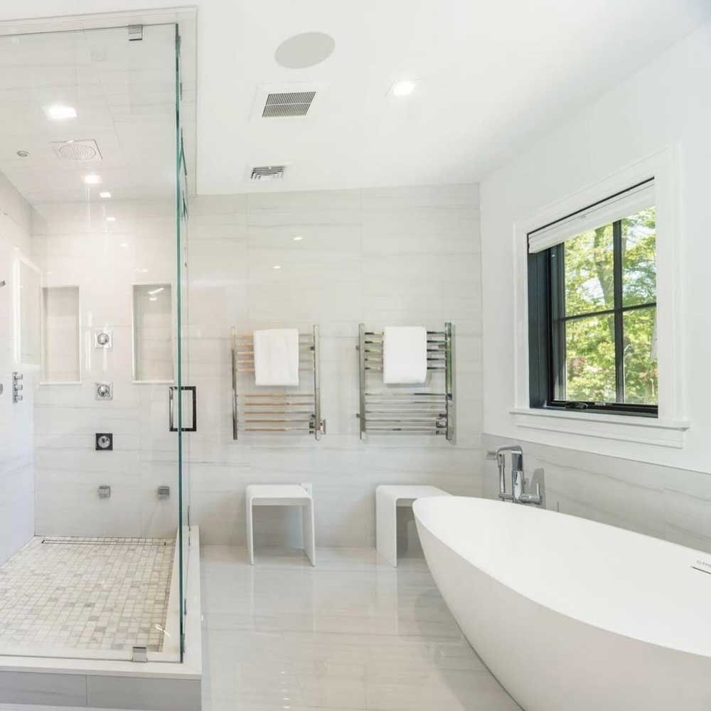 A bathroom with a tub , shower , and window.