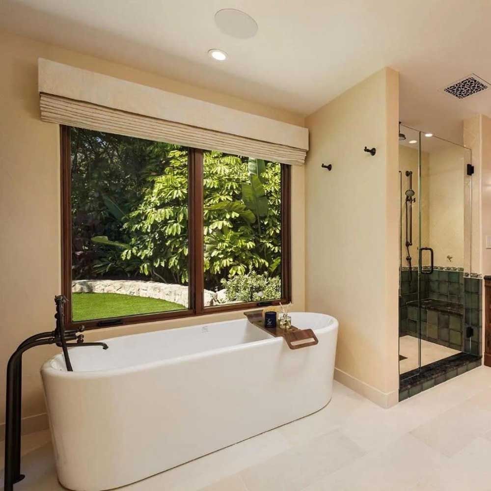 A bathtub in a bathroom with a large window