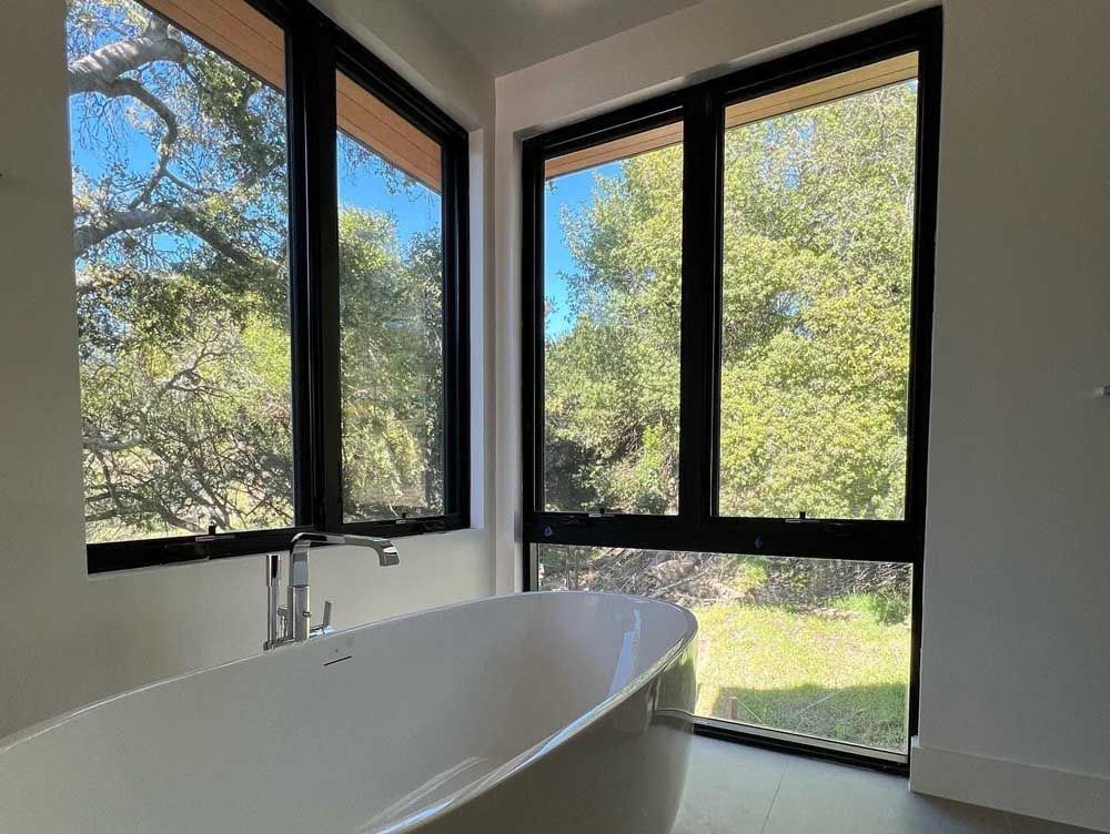 A bathroom with a bathtub and a lot of windows.