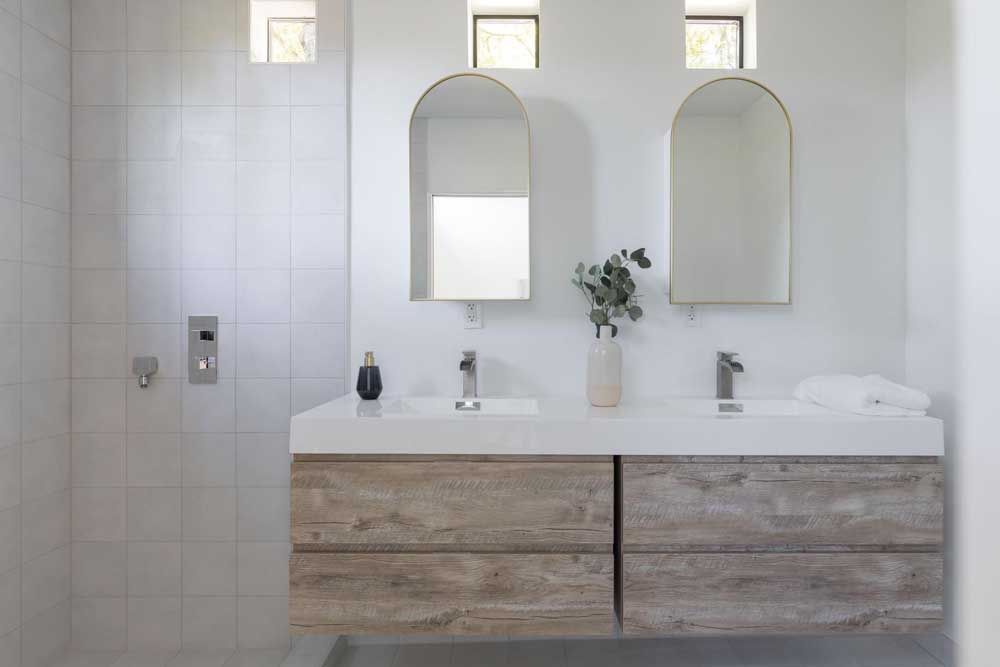 A bathroom with two sinks and two mirrors.