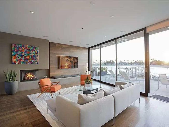 A living room with a couch , chairs , fireplace and sliding glass doors.