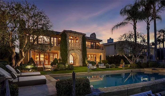 A large house with a swimming pool in front of it