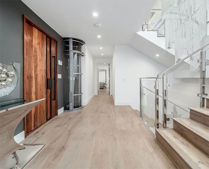 A hallway with wooden floors and stairs in a house