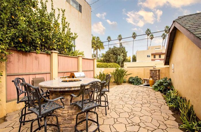 A patio with a table and chairs and a fire pit