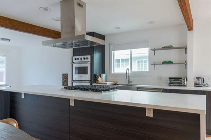 A kitchen with a large island and a stove top oven.