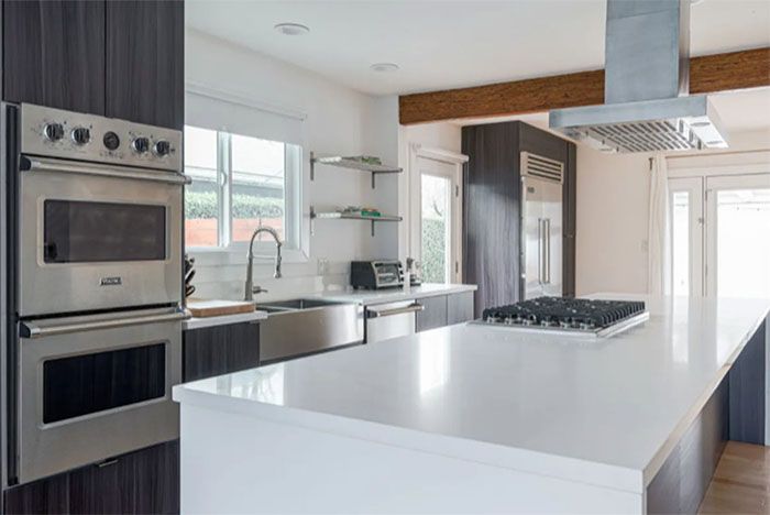A kitchen with stainless steel appliances and a large island.