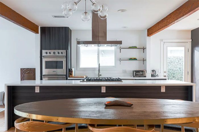 A kitchen with a table and chairs and a stove top oven.