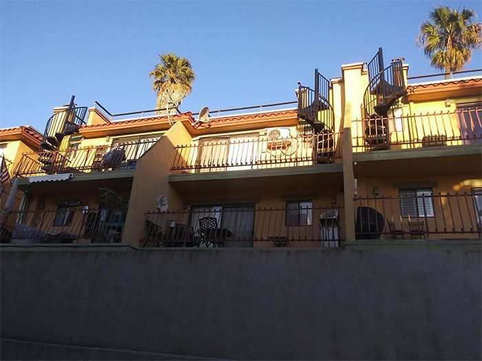A row of apartment buildings with balconies and stairs