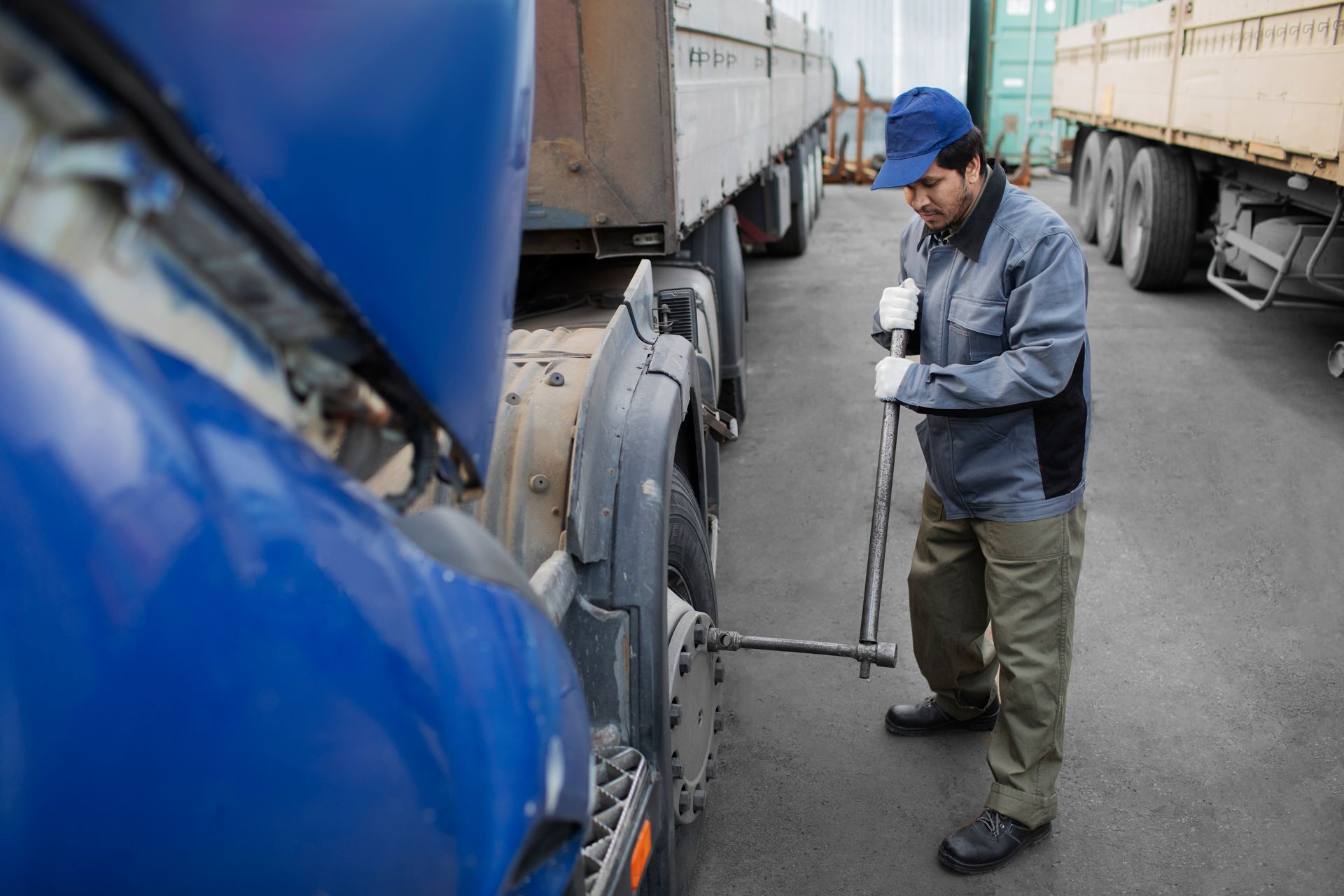 A man is changing a tire on a semi truck.