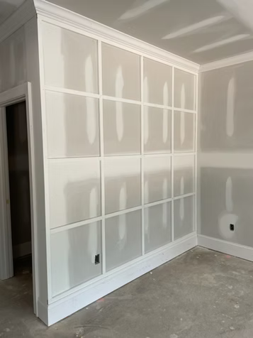 Interior view of a wall with a grid pattern made of white trim.