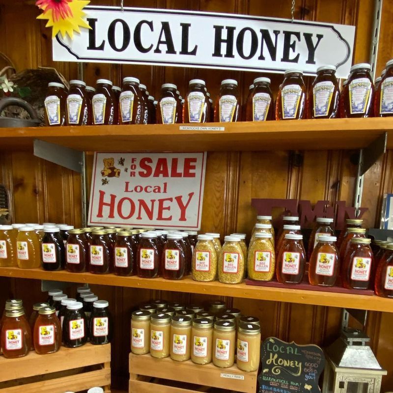 Wooden shelves in a shop stocked with many jars of local honey, featuring several