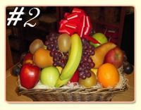A fruit basket featuring a red apple, green apple, banana, grapes, orange, pear, and kiwi, topped with a red gift bow.