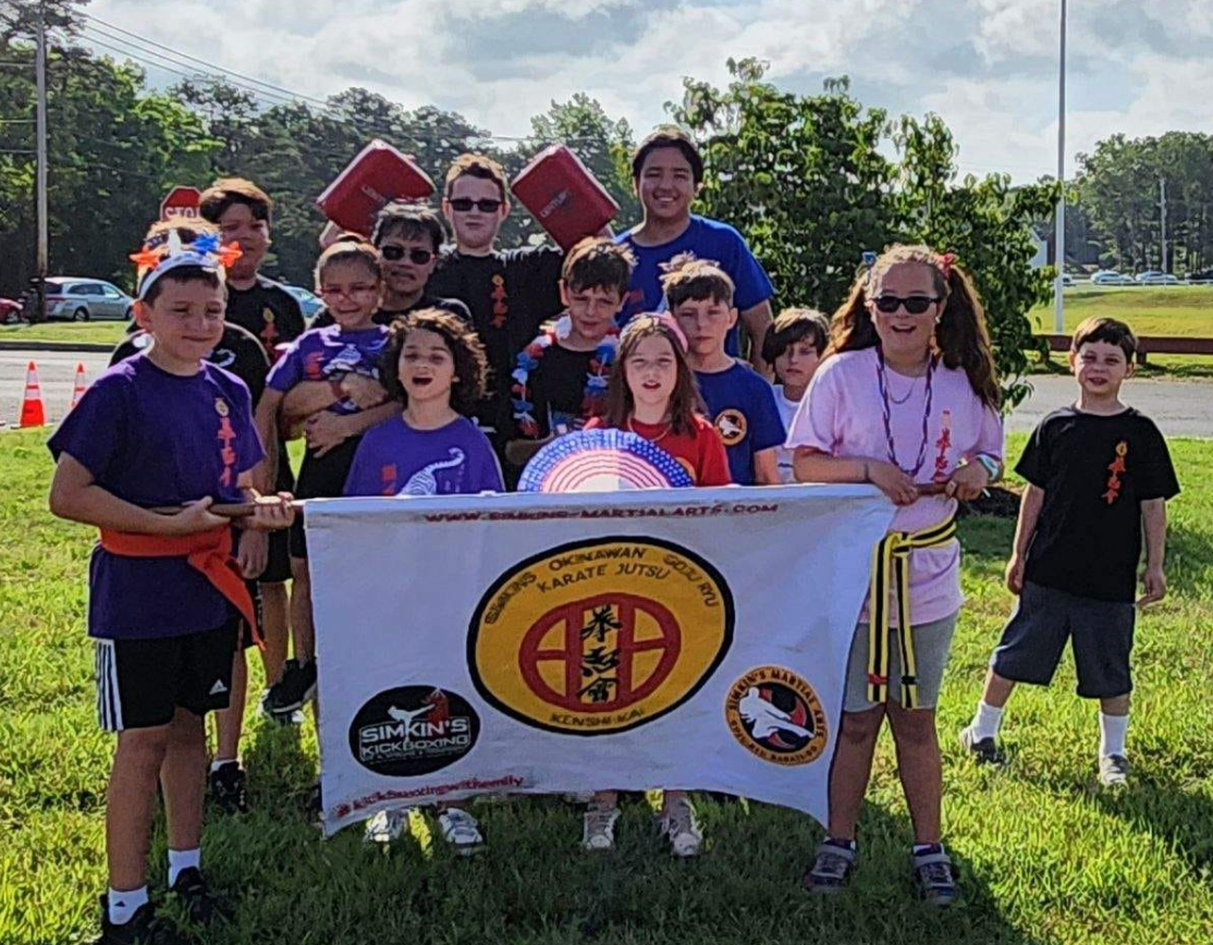 A group of children are posing for a picture while holding a flag