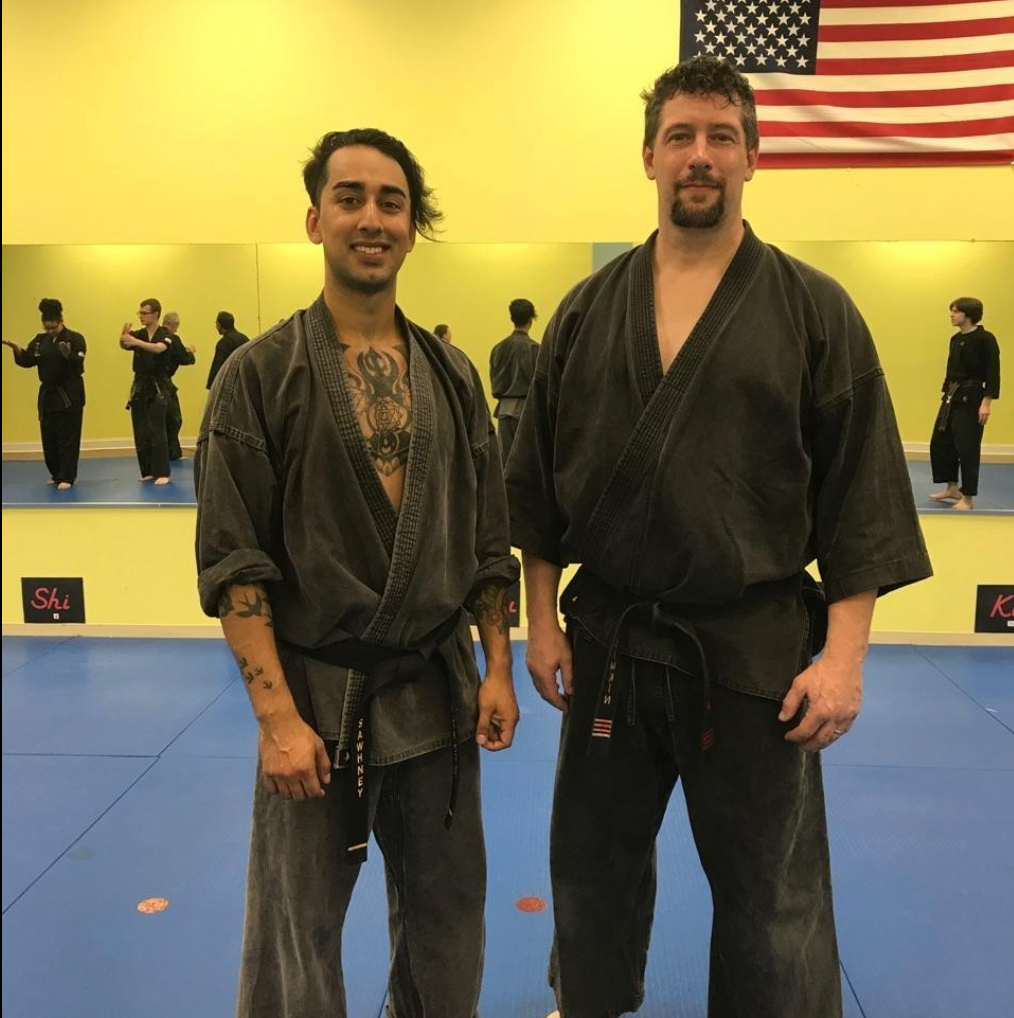 Two men standing next to each other in front of an american flag