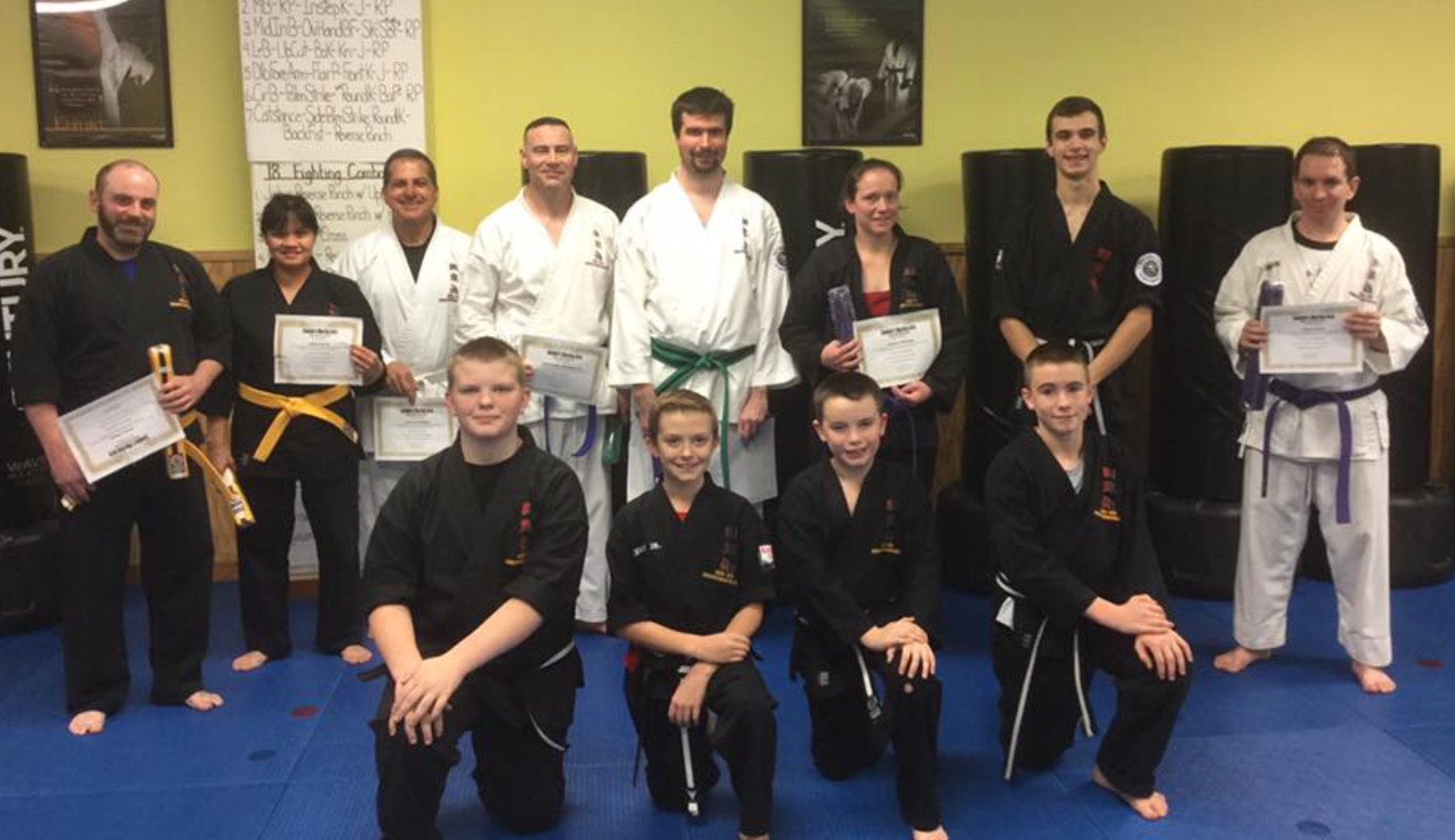 A group of people are posing for a picture in a gym.