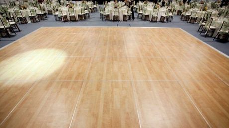 Wooden dance floor with tables and chairs set up for an event.