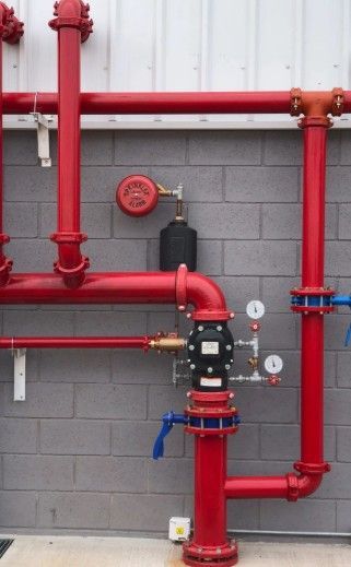 Camión de bomberos rojo y blanco con escalera extendida, etiquetado 