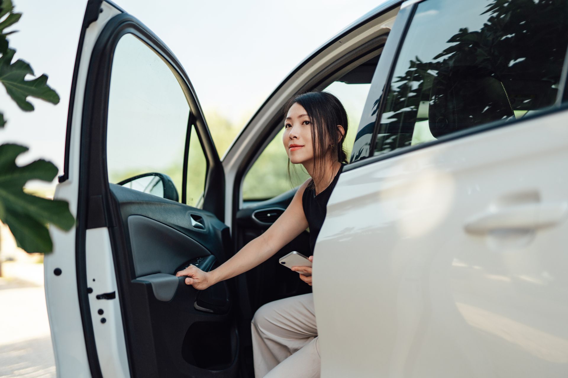 Businesswoman leaving a car upon arrival, highlighting reliable business auto insurance.