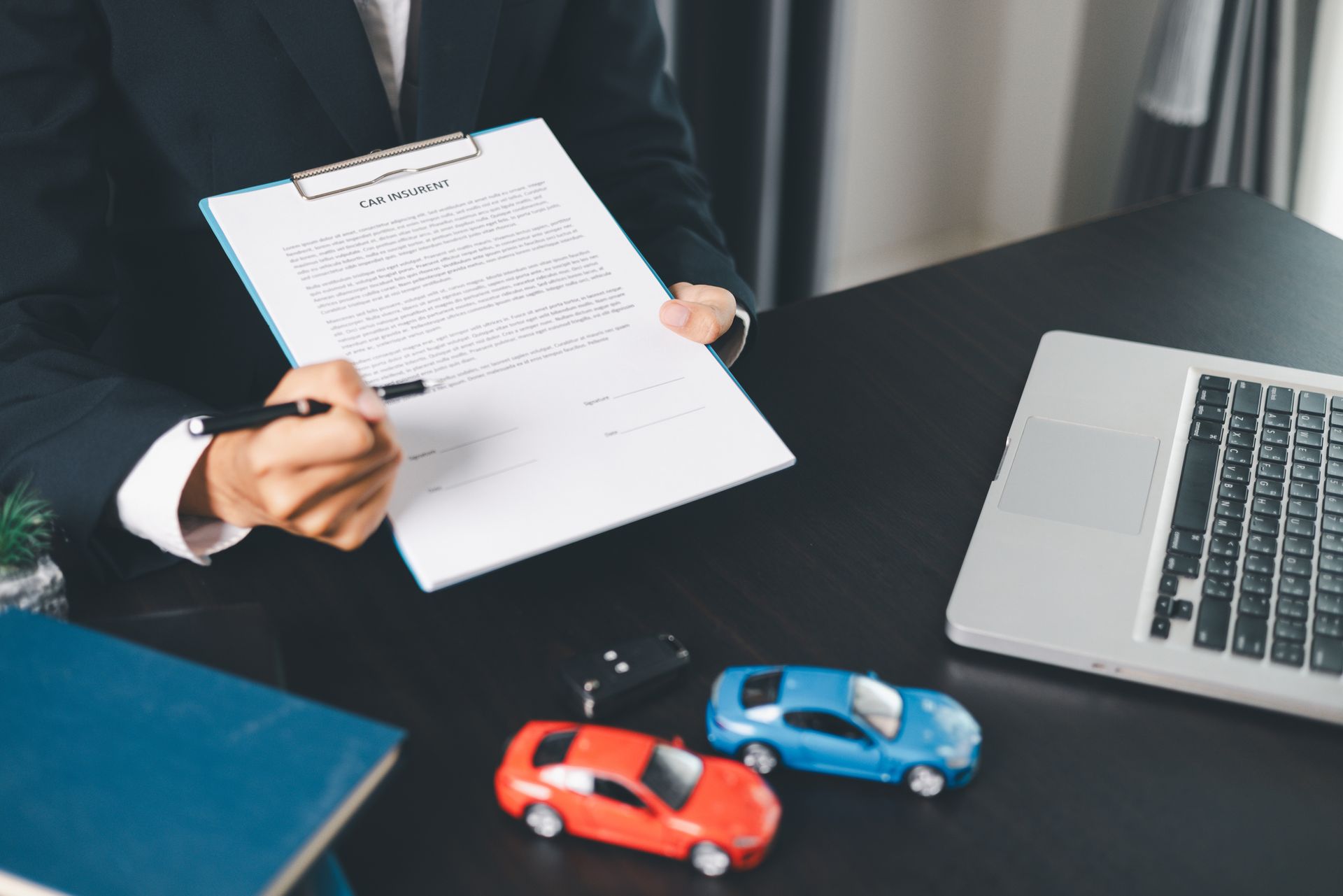 An insurance agent reviewing car insurance coverage with a client. An insurance agent reviewing car insurance coverage with a client.