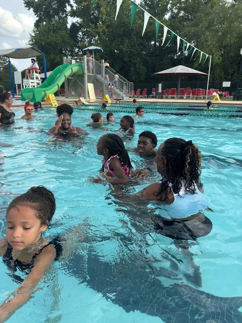 A group of children are swimming in a swimming pool.
