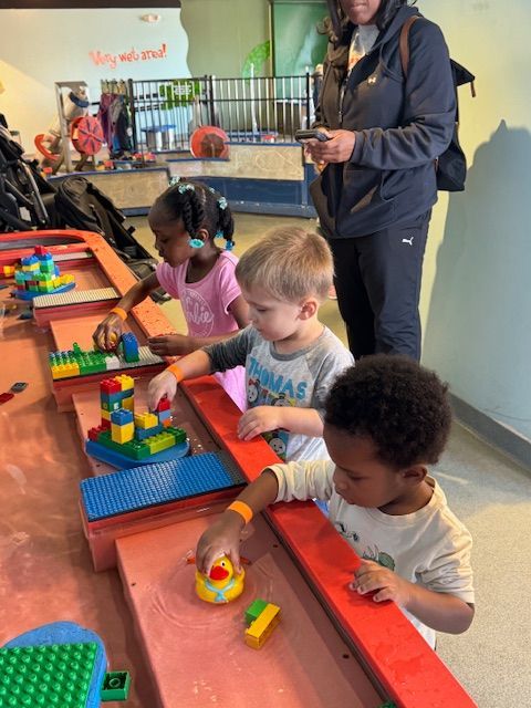 A group of children are playing with lego blocks on a table