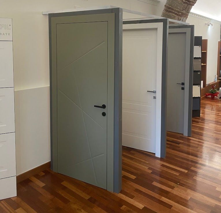 Corridoio con diverse porte interne, alcune aperte e altre chiuse, nei colori grigio, bianco e verde oliva.