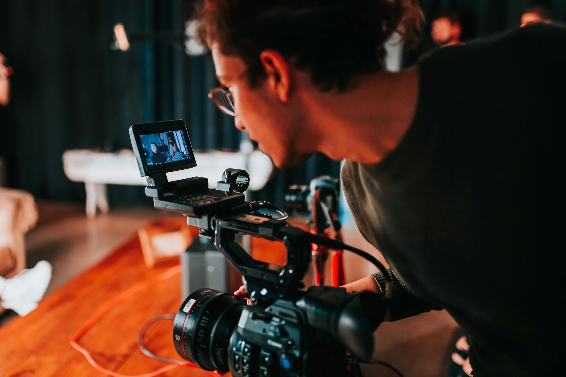 A man is holding a camera and looking at the screen.