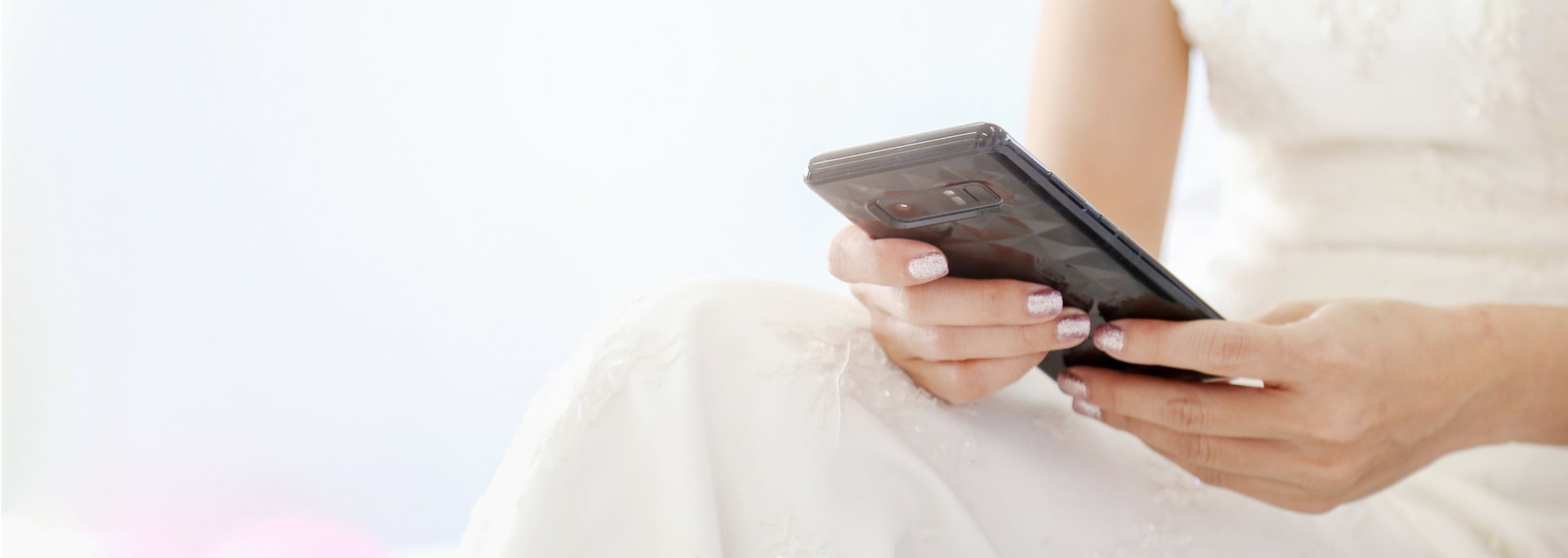 Picture of someone in a wedding dress using a smartphone. Picture of someone in a wedding dress using a smartphone.