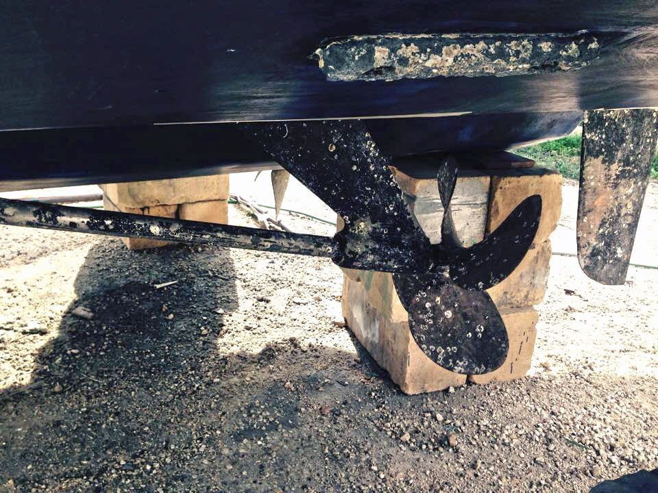 A boat propeller is sitting on a wooden block